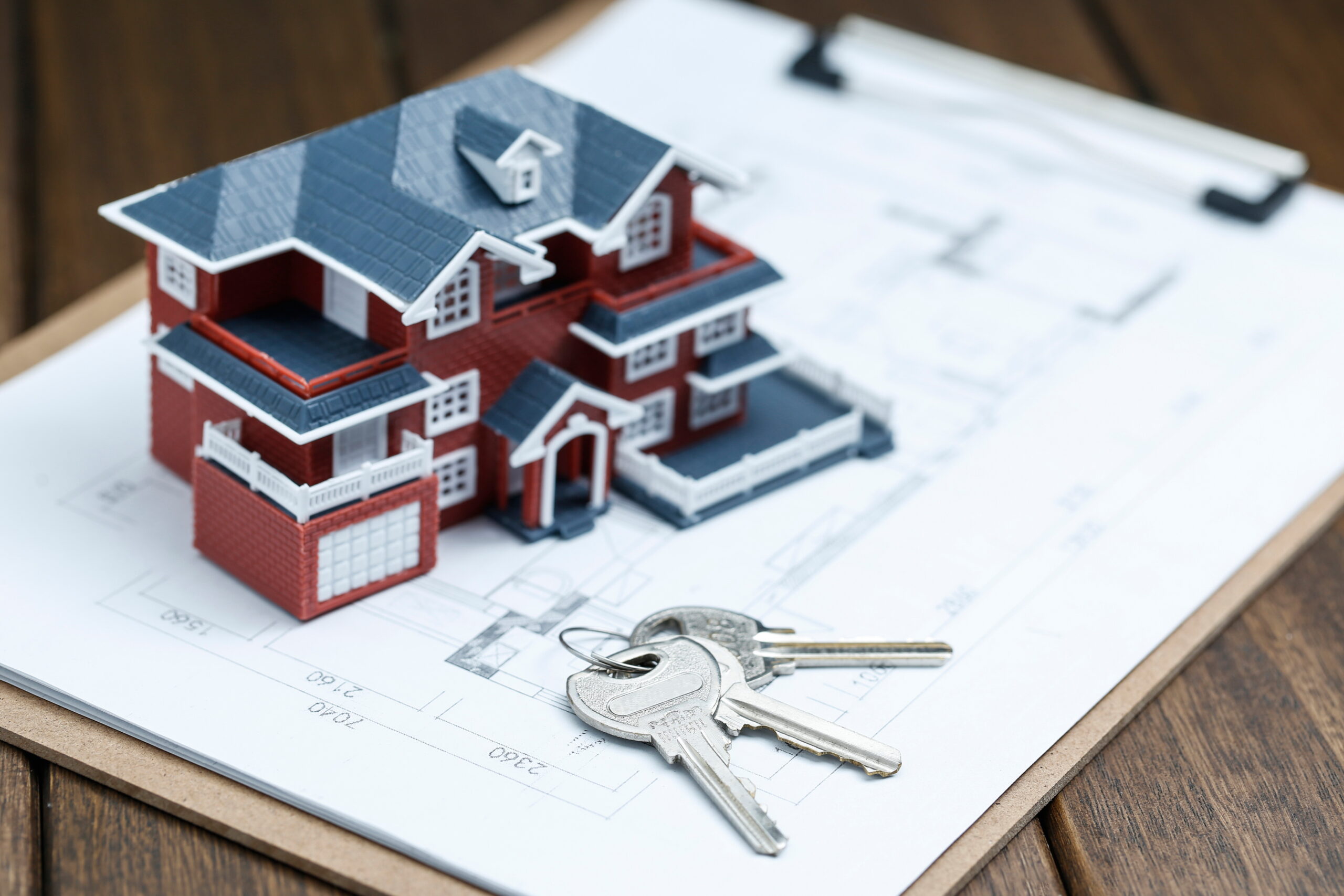 villa house model, key and drawing on retro desktop (real estate sale concept)